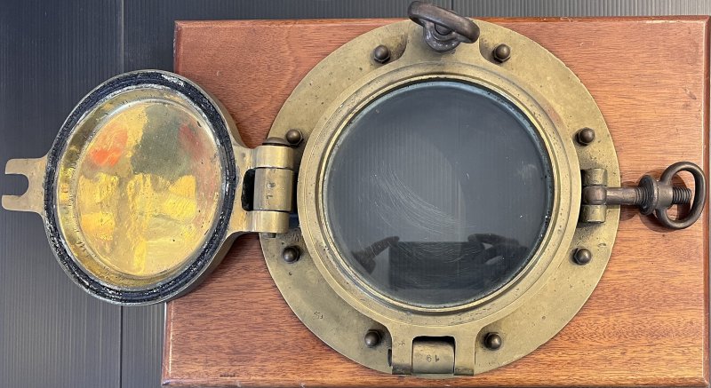 Oblò in ottone su tavola di mogano